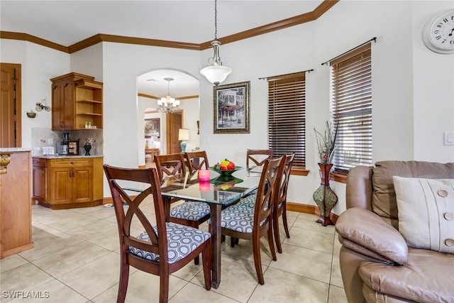 dining room with light tile patterned flooring, an inviting chandelier, and crown molding