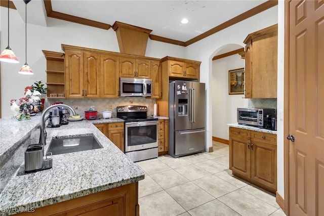 kitchen featuring stainless steel appliances, sink, light stone countertops, pendant lighting, and decorative backsplash