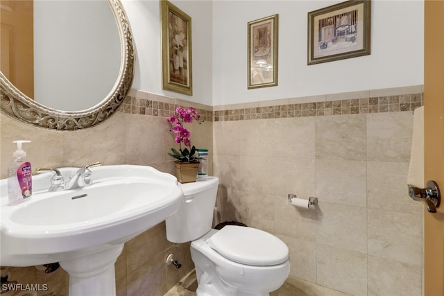 bathroom featuring toilet and tile walls