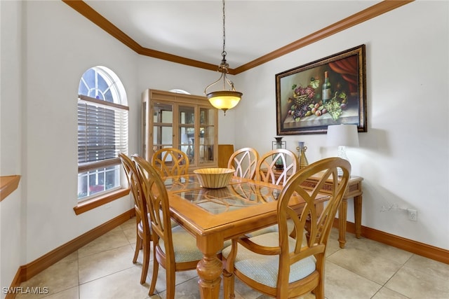 dining space with light tile patterned flooring and crown molding