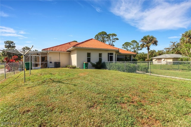 back of property with glass enclosure, a lawn, and central air condition unit