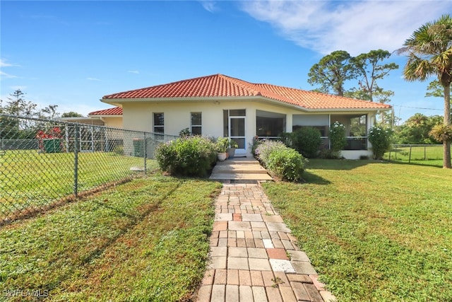 rear view of house with a sunroom and a yard