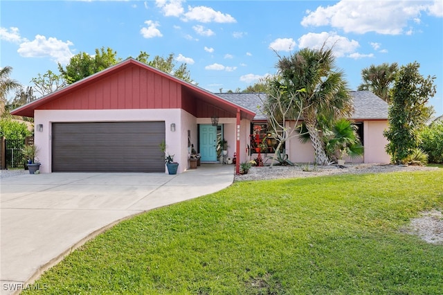 view of front of home featuring a garage, driveway, a front lawn, and stucco siding