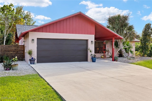 view of front facade featuring driveway, an attached garage, fence, and stucco siding