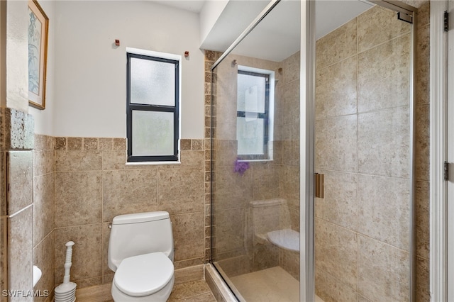 bathroom featuring an enclosed shower, tile walls, and toilet