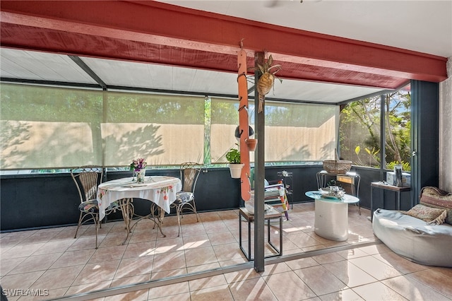 sunroom / solarium featuring beam ceiling and plenty of natural light