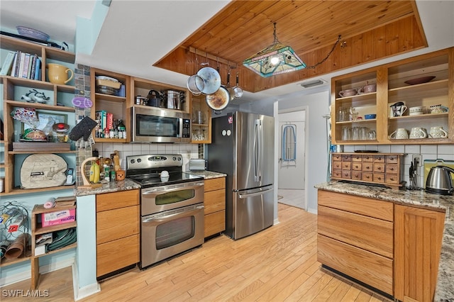 kitchen featuring tasteful backsplash, light stone countertops, light hardwood / wood-style flooring, and stainless steel appliances