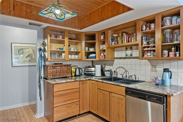 kitchen with backsplash, dishwasher, light stone countertops, and sink