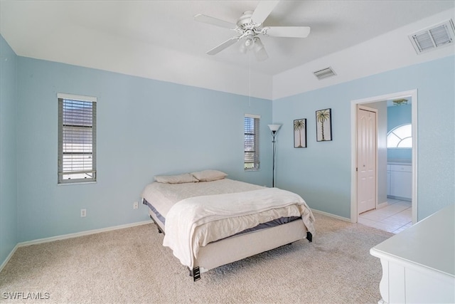 carpeted bedroom with ceiling fan and ensuite bath