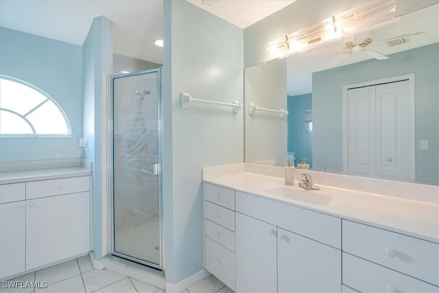 bathroom with tile patterned floors, ceiling fan, a shower with door, and vanity