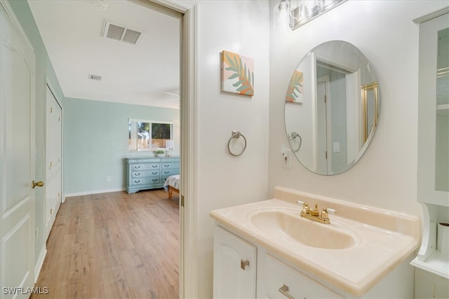 bathroom with hardwood / wood-style floors and vanity