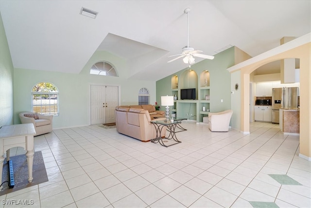 living room with ceiling fan, built in features, light tile patterned floors, and vaulted ceiling