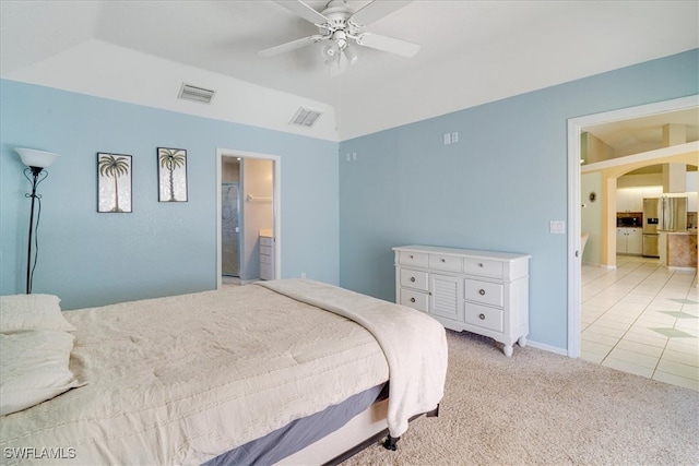 bedroom featuring stainless steel fridge, ensuite bathroom, ceiling fan, and light carpet