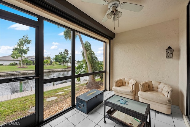 sunroom with a water view, ceiling fan, and a healthy amount of sunlight