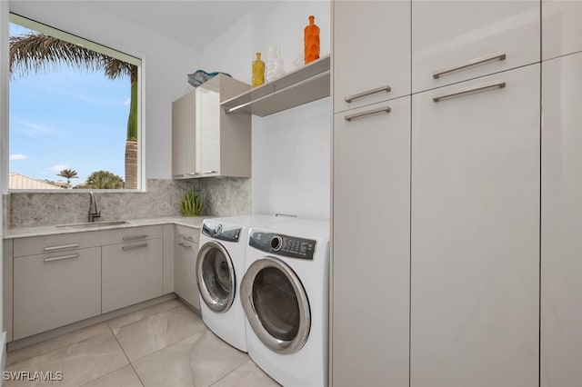 laundry room featuring sink, cabinets, and independent washer and dryer