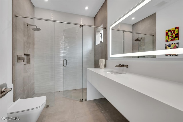 bathroom featuring a shower with door, tile patterned flooring, tile walls, vanity, and toilet