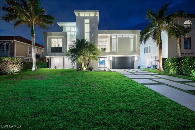 view of front of house featuring a front lawn and a garage