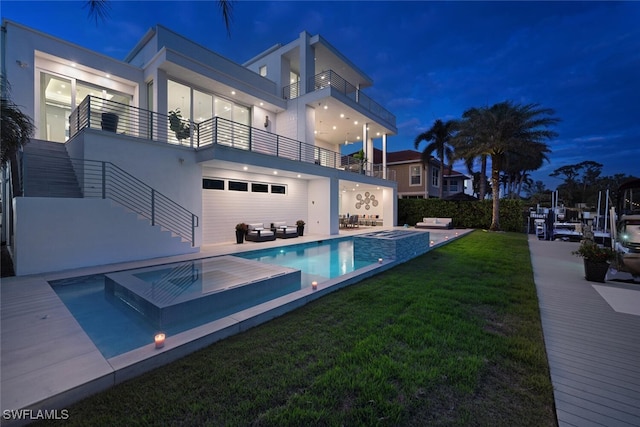 rear view of property featuring a swimming pool with hot tub, an outdoor hangout area, a balcony, and a patio area