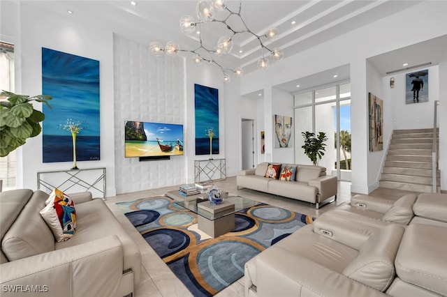 living room featuring a towering ceiling and a notable chandelier