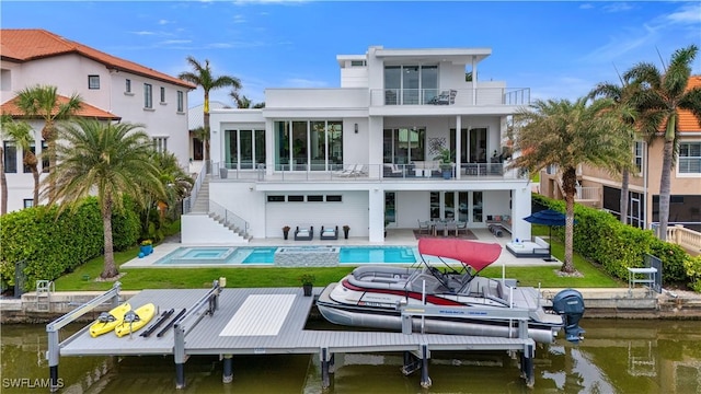 back of house featuring a water view, a balcony, and a patio