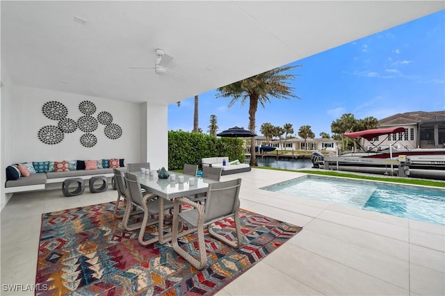 view of pool with a water view, ceiling fan, an outdoor hangout area, and a patio area