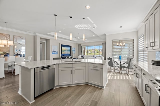 kitchen with hanging light fixtures, sink, a center island with sink, and stainless steel appliances