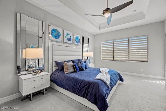 carpeted bedroom featuring crown molding, ceiling fan, and a raised ceiling