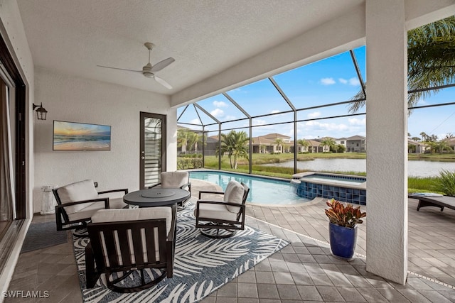 view of patio featuring ceiling fan, glass enclosure, a water view, and a swimming pool with hot tub