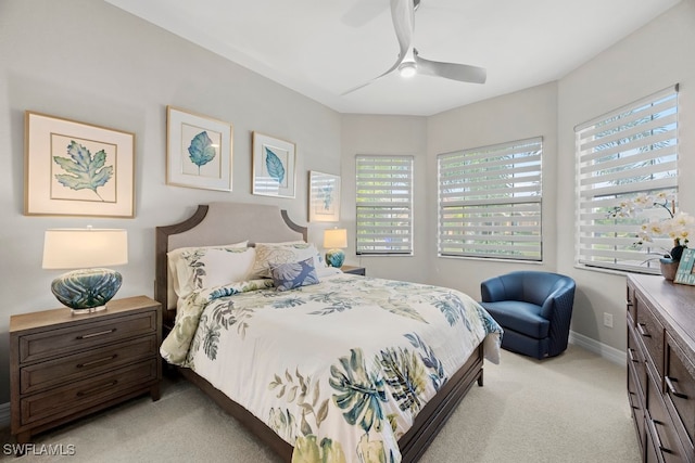 bedroom with light colored carpet, multiple windows, and ceiling fan