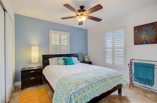 bedroom featuring ceiling fan, multiple windows, and a closet