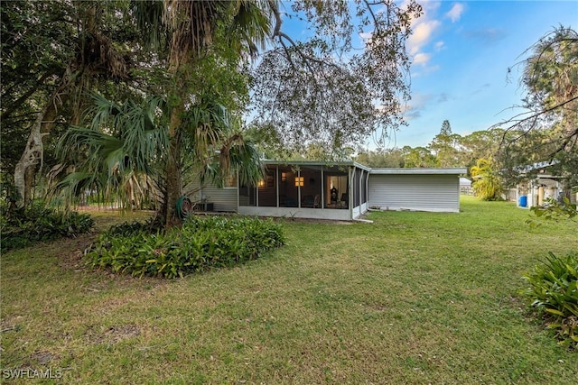 back of house featuring a sunroom and a yard