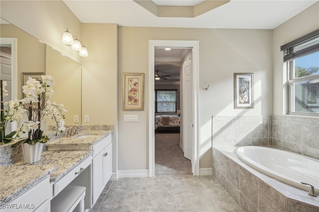 bathroom with tile patterned floors, tiled tub, crown molding, vanity, and ceiling fan