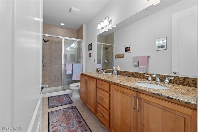 bathroom with tile patterned flooring, vanity, toilet, and walk in shower