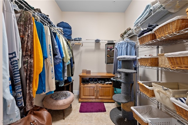 walk in closet with light tile patterned floors