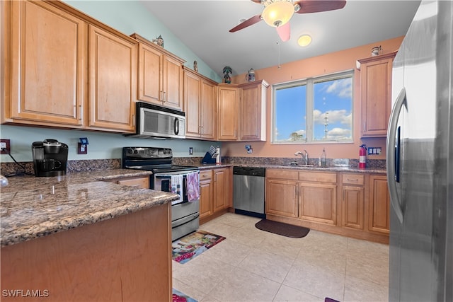 kitchen featuring appliances with stainless steel finishes, vaulted ceiling, ceiling fan, sink, and dark stone countertops