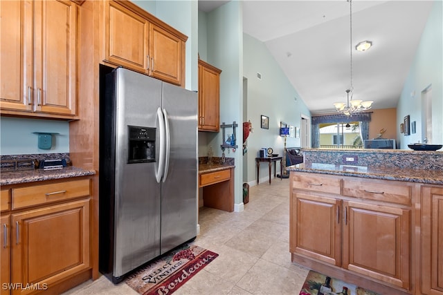 kitchen with stainless steel refrigerator with ice dispenser, a notable chandelier, dark stone counters, lofted ceiling, and decorative light fixtures