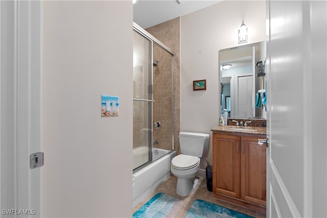 full bathroom featuring tile patterned flooring, vanity, toilet, and bath / shower combo with glass door