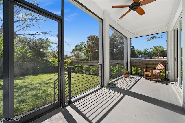 unfurnished sunroom with a wealth of natural light and ceiling fan