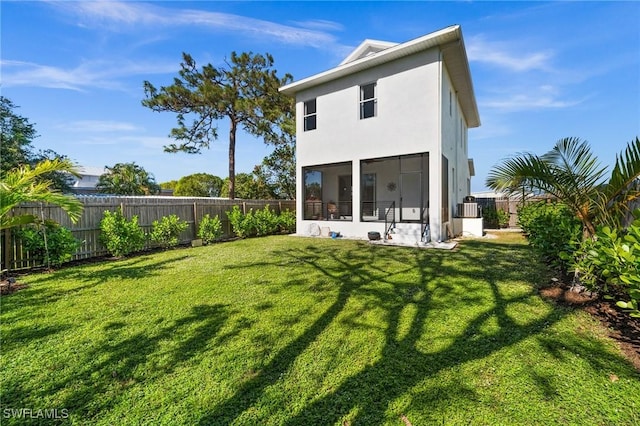 rear view of property featuring a lawn, cooling unit, and a sunroom