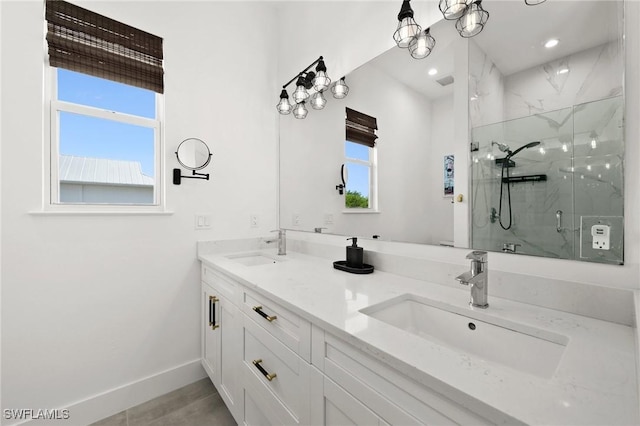 bathroom with vanity, a healthy amount of sunlight, and a shower with shower door