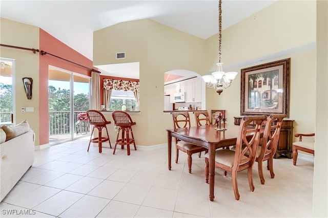 dining space featuring light tile patterned flooring, a notable chandelier, and vaulted ceiling