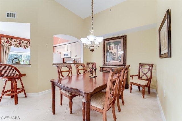 dining area featuring high vaulted ceiling and a chandelier