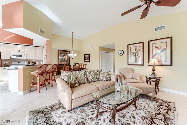 tiled living room featuring ceiling fan with notable chandelier and vaulted ceiling