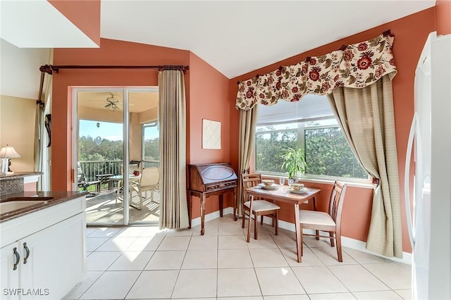 living area featuring vaulted ceiling, light tile patterned floors, and sink