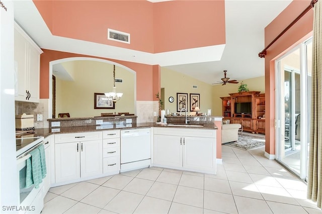 kitchen with sink, white cabinets, kitchen peninsula, and white appliances