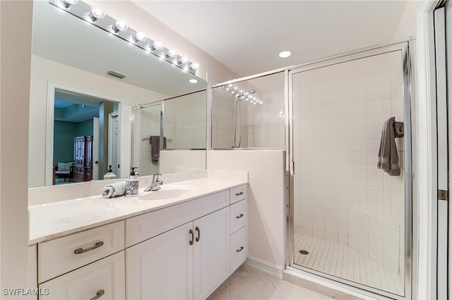 bathroom featuring a shower with shower door, vanity, and tile patterned floors