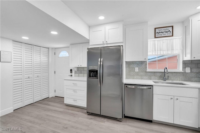 kitchen with light hardwood / wood-style flooring, stainless steel appliances, white cabinetry, and sink