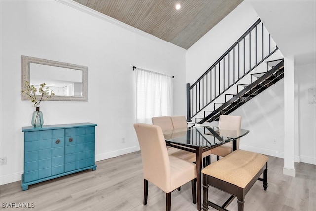 dining space featuring a high ceiling, hardwood / wood-style flooring, and wood ceiling