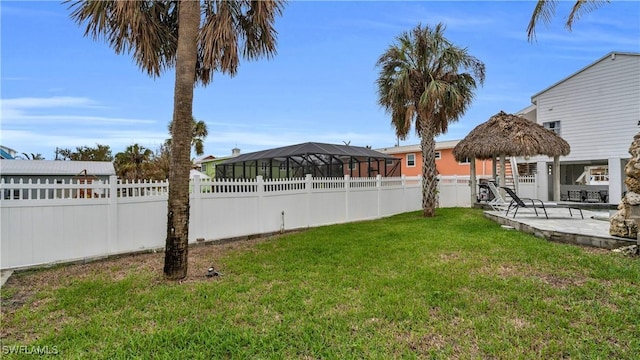 view of yard with a lanai, a fenced backyard, a patio, and a gazebo