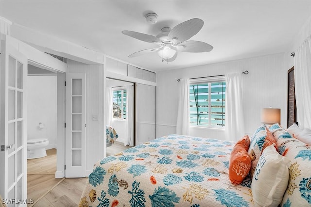 bedroom with light wood-style floors, french doors, multiple windows, and a closet